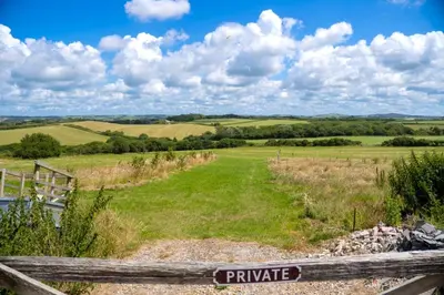 a fence with a private sign on it in a field at Finest Retreats - Rosemary Cottage in Widemouth Bay