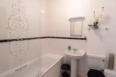 a bathroom with a tub and a sink and a toilet at Finest Retreats - Rosemary Cottage in Widemouth Bay