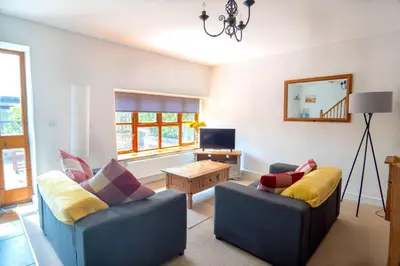 a living room with two chairs and a table at Finest Retreats - Rosemary Cottage in Widemouth Bay