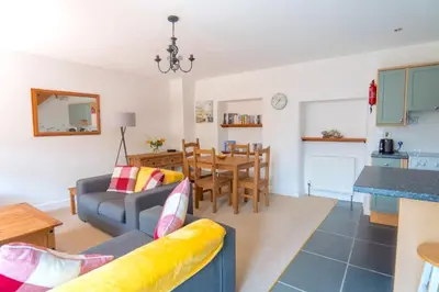 a living room with a couch and a table at Finest Retreats - Rosemary Cottage in Widemouth Bay