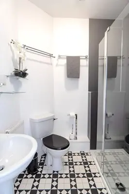 a white bathroom with a toilet and a sink at Finest Retreats - Olive Tree in Widemouth Bay