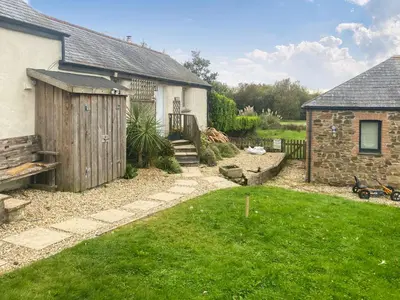 a backyard with a house and a yard with green grass at Swallows in Porthscatho