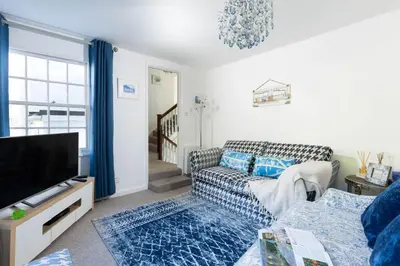 a living room with a couch and a tv at Mariners Cottage in Saint Mawes