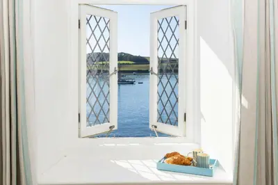an open window with a view of the water at Mariners Cottage in Saint Mawes
