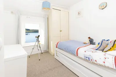 a bedroom with a bed with a camera on a tripod at Mariners Cottage in Saint Mawes