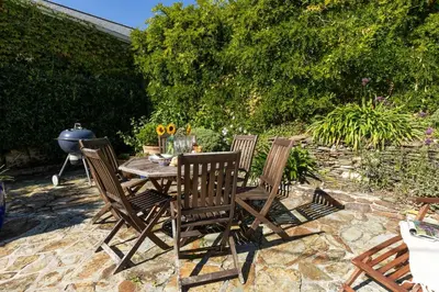 a wooden table and chairs on a patio at Mariners Cottage in Saint Mawes
