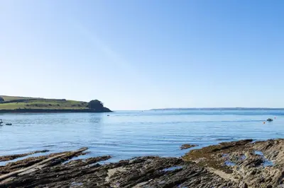a view of a body of water with rocks at Mariners Cottage in Saint Mawes