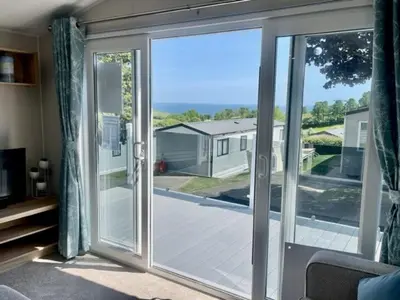 an open sliding glass door with a view of a yard at Polperro Seaside Retreat in Polperro