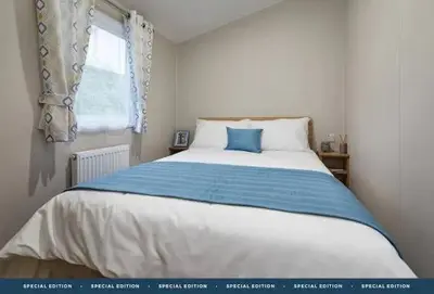 a bedroom with a large bed with a blue pillow at Polperro Seaside Retreat in Polperro