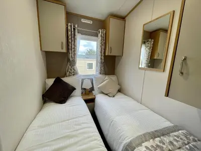two beds in a small room with a window at Polperro Seaview Retreat in Polperro