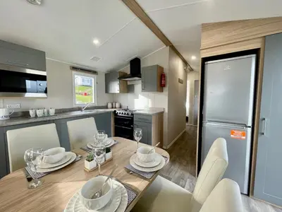 a kitchen with a wooden table with plates and glasses on it at Polperro Seaview Retreat in Polperro