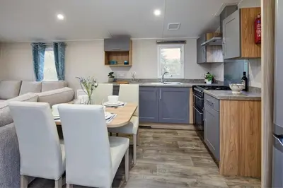 a kitchen and living room with a table and chairs at Polperro Seaview Retreat in Polperro