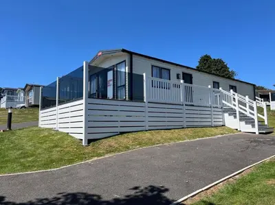 a house with a white fence on the side of a road at Polperro Seaview Lodge in Polperro