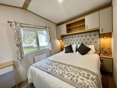 a bedroom with a large bed and a window at Polperro Seaview Lodge in Polperro