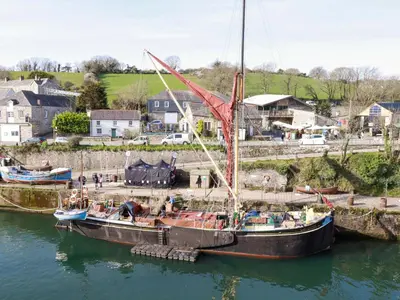 two boats are docked in the water in a harbor at Yonja Homes in St Austell