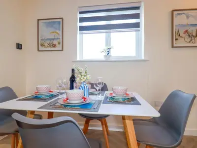 a dining room with a white table and chairs at Yonja Homes in St Austell