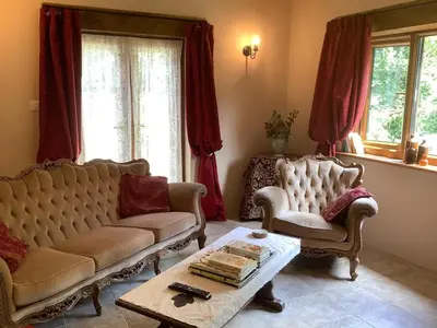 a living room with a couch and two chairs and a table at Poldurn in St Austell