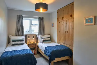 a bedroom with two beds and a window at Finest Retreats - Gwelmor in Widemouth Bay