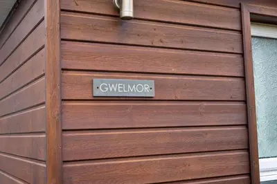 a wooden garage door with a sign on it at Finest Retreats - Gwelmor in Widemouth Bay