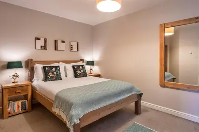 a bedroom with a bed and a mirror at Finest Retreats - Gwelmor in Widemouth Bay