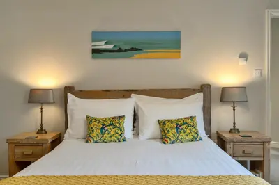 a bedroom with a white bed with two night stands at Finest Retreats - Gwelmor in Widemouth Bay