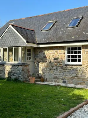 a stone house with windows and a yard at The Old Piggery, countryside barn with hot tub in Leedstown