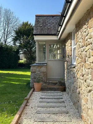 a front door of a brick house with a stone wall at The Old Piggery, countryside barn with hot tub in Leedstown