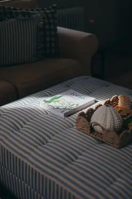 a bed with a book and a stuffed animal on it at The Old Piggery, countryside barn with hot tub in Leedstown