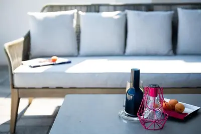 a table with a white couch and a bottle of wine at Fistral house Beachfront Bliss in Crantock
