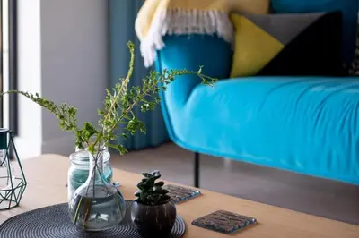 a living room with a blue couch and a table at Fistral house Beachfront Bliss in Crantock