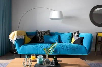 a blue couch in a living room with a table at Fistral house Beachfront Bliss in Crantock