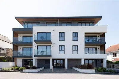 a large white building with a lot of windows at Fistral house Beachfront Bliss in Crantock