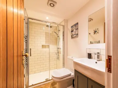 a bathroom with a toilet and a sink and a shower at Holiday Home Shanty Cottage by Interhome in Mevagissey
