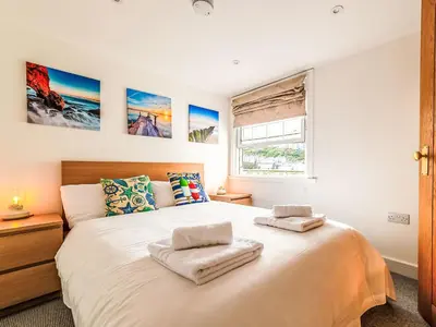 a bedroom with a large bed with two towels on it at Holiday Home Shanty Cottage by Interhome in Mevagissey