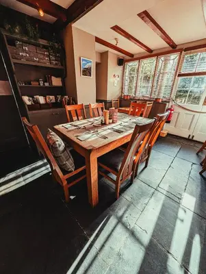 a dining room with a wooden table and chairs at The Falcon Inn in Saint Mawgan