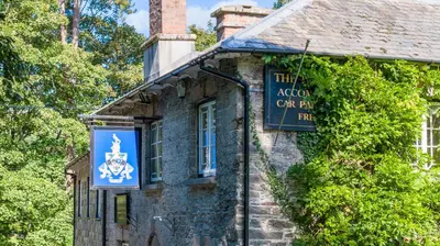 an old stone building with a sign on it at The Falcon Inn in Saint Mawgan
