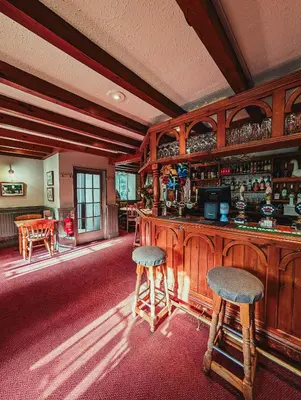 a bar with two stools in a room at The Falcon Inn in Saint Mawgan
