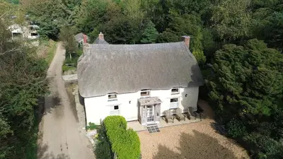an aerial view of a white house in the woods at Plenteth in Truro