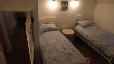 two twin beds in a small room with a table at Plenteth in Truro