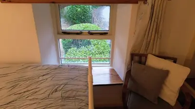 a bedroom with a bed and a large window at Plenteth in Truro