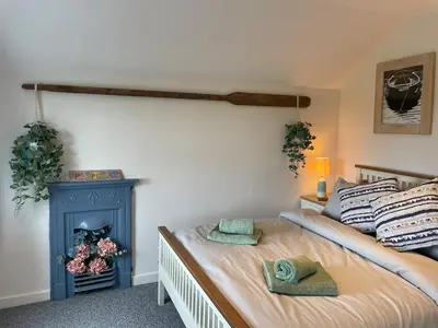 a bedroom with a bed and a blue fireplace at Hideaway Cottage in Polperro