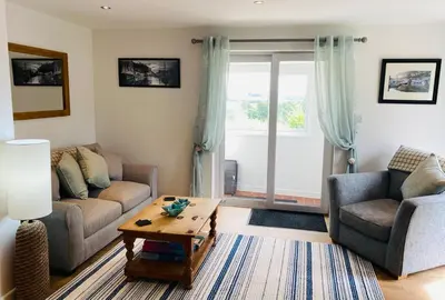 a living room with two couches and a coffee table at Hideaway Cottage in Polperro