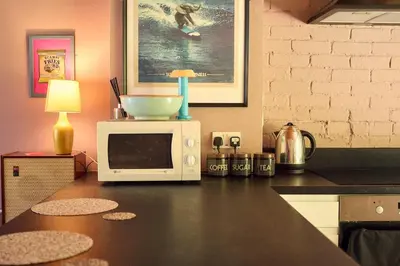 a kitchen counter with a microwave and a bowl on it at Little Pol in Saint Columb Road Station