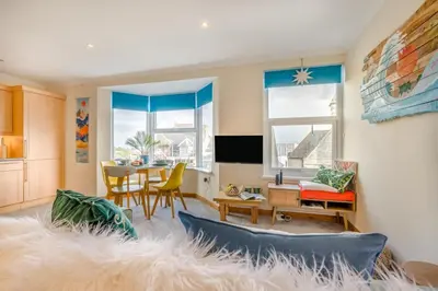 a living room with a table and chairs and a large rug at 1 Bed in Newquay oc-o33805 in Newquay