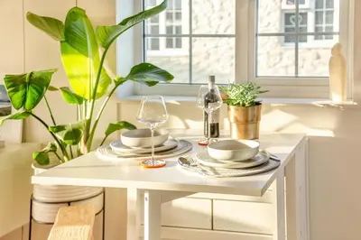 a white table with plates and glasses and plants at 2 Bed in Trevarrian oc-c33855 in Mawgan Porth