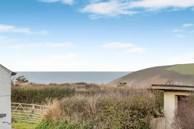 a view of a field with a hill in the background at 2 Bed in Trevarrian oc-c33855 in Mawgan Porth