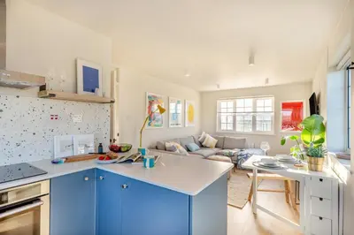 a kitchen and living room with blue cabinets and a couch at 2 Bed in Trevarrian oc-c33855 in Mawgan Porth