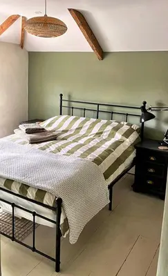 a bed in a bedroom with a green wall at The Locker, 2 bed apartment in Falmouth in Falmouth