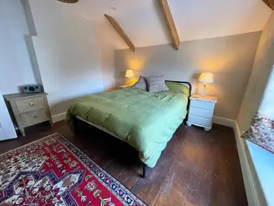 a bedroom with a green bed with two lamps and a rug at The Locker, 2 bed apartment in Falmouth in Falmouth