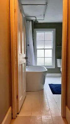 a bathroom with a bath tub and a window at The Locker, 2 bed apartment in Falmouth in Falmouth